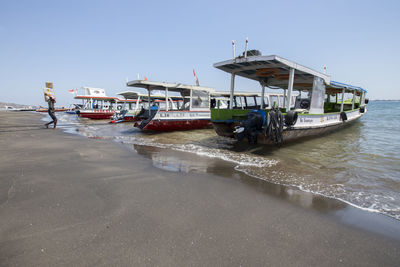 Boat moored on beach against clear sky