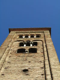 Low angle view of old building against clear blue sky