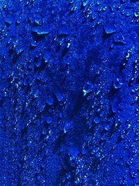 Full frame shot of raindrops on blue surface