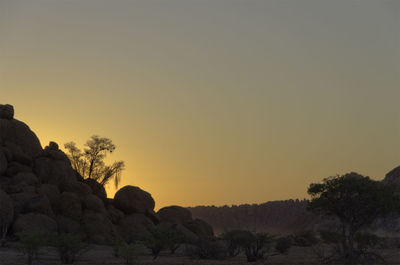 Silhouette rock formations against sky during sunset