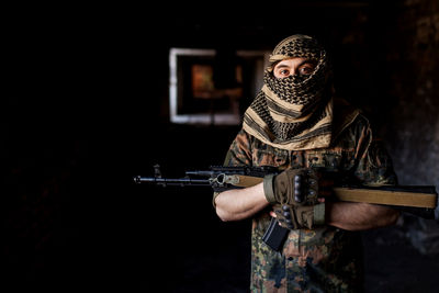 Portrait of serious middle eastern man with ak-47