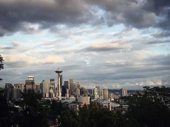 Modern cityscape against cloudy sky