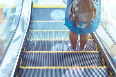 Low section of woman on escalator