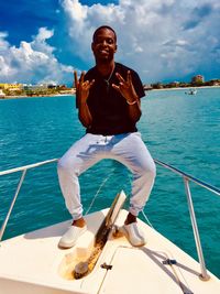 Full length of young man standing by sea against sky