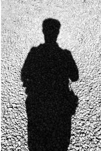 Shadow of person on footpath in city