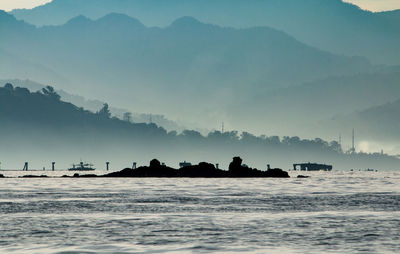 Silhouette boats in sea against sky