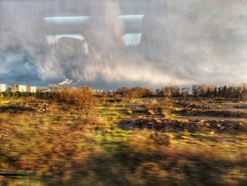 Digital composite image of buildings on field against sky