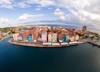 High angle view of townscape by sea against sky