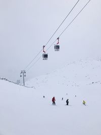 People skiing over ski lift during winter