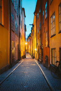 Illuminated street amidst buildings in town