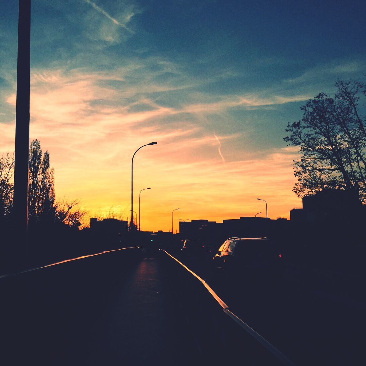 sunset, transportation, the way forward, road, sky, tree, diminishing perspective, street light, silhouette, car, street, vanishing point, cloud - sky, road marking, land vehicle, orange color, empty, dusk, mode of transport, no people