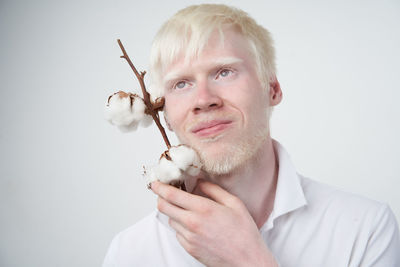 Portrait of man holding hands over white background