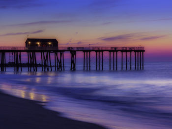 Silhouette pier on sea against sky at sunset