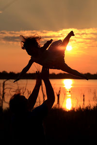 Playful parent and child at sunset 