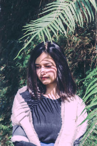 Portrait of a smiling young woman against plants