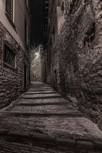 Empty narrow alley along buildings