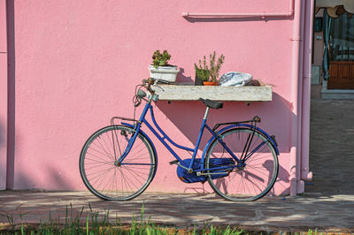 Close-up of bicycle leaning against colorful wall in burano, a little town full of canals in italy.