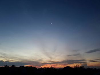 Scenic view of silhouette moon against sky at sunset