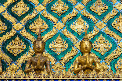Low angle view of golden sculptures on wall at temple