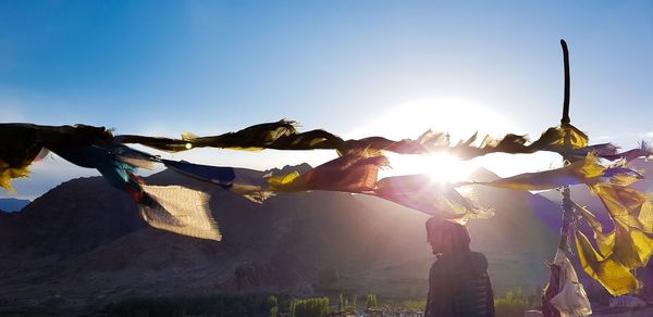 Man standing by prayer flag during sunny day