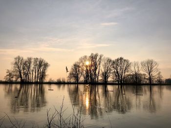 Scenic view of lake against sky at sunset