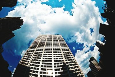 Low angle view of modern building against cloudy sky