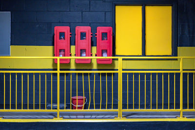 Close-up of yellow metal railing of building