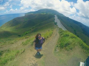 Woman standing on mountain against sky