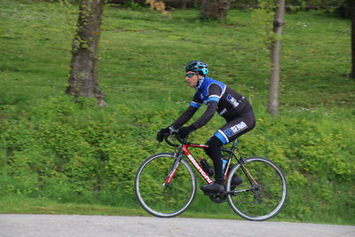 Side view of man riding bicycle on street