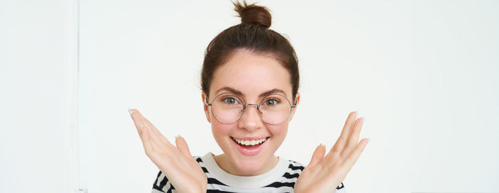 Portrait of smiling young woman against white background