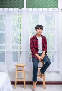 Portrait of young man sitting on chair