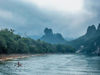 High angle view of man on wooden raft sailing in river