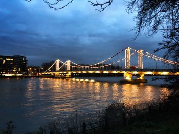 View of suspension bridge over river at night