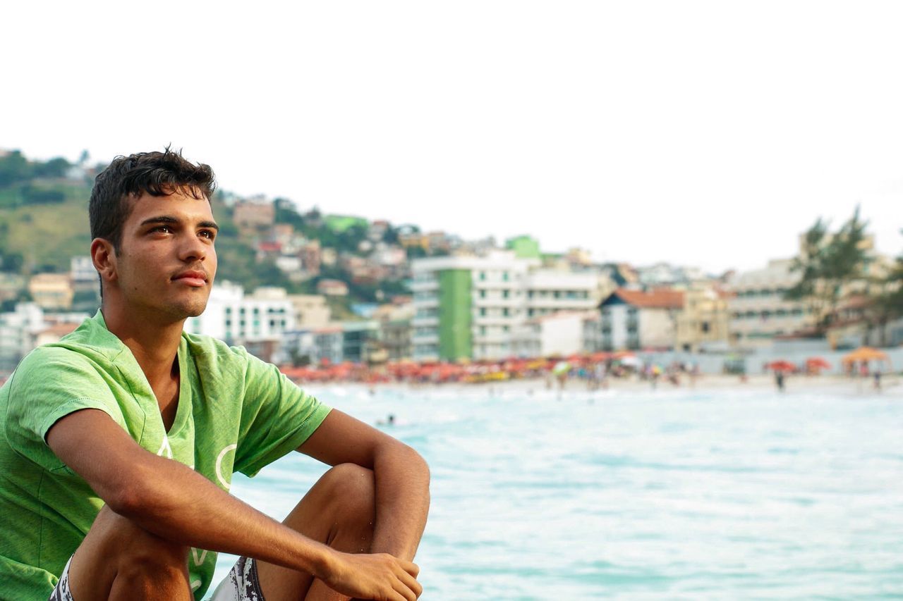 PORTRAIT OF YOUNG MAN AGAINST SKY