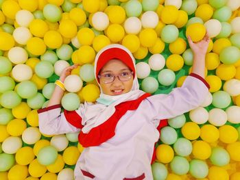 A little girl look happy when playing colourful balls
