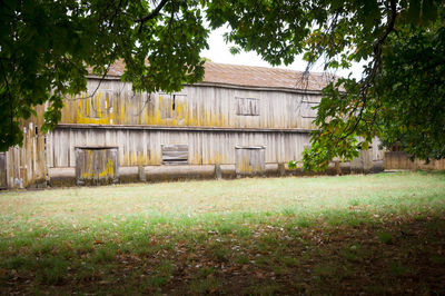 House on field against trees and houses