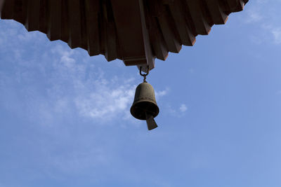 Low angle view of hanging lights against blue sky