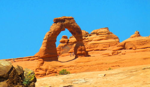 Low angle view of rock formations against clear blue sky