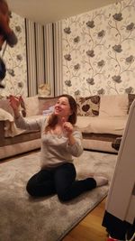 Young woman sitting on sofa at home