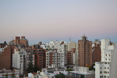 Buildings in city against clear sky
