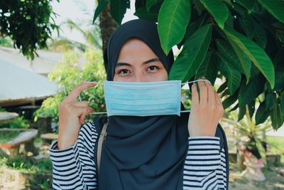 Portrait of teenage girl holding face mask amid of covid19 