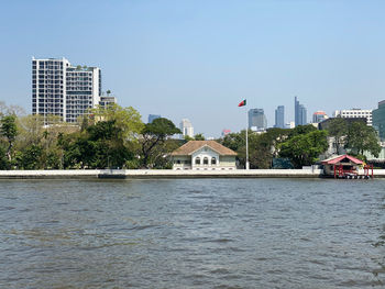 River by buildings against sky in city