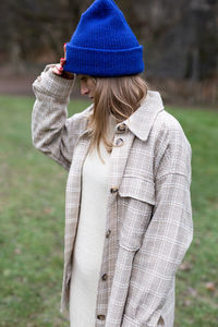 Midsection of woman wearing hat standing on field