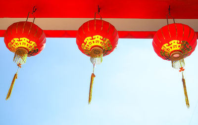 Low angle view of chinese lanterns on ceiling against clear sky