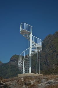 Low angle view of staircase against clear blue sky