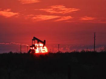 Setting sun and pump jack silhouette