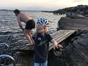 Friends enjoying in sea against sky