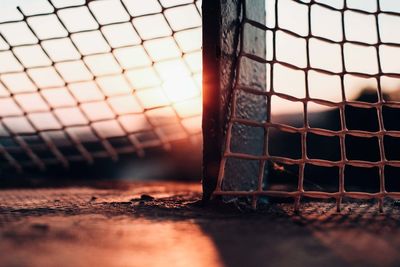 Close-up of metallic fence during sunset