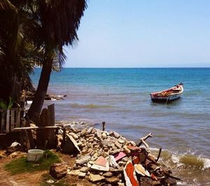 Abandoned boat on beach against clear sky