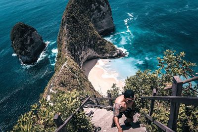 High angle view of woman on rock by sea